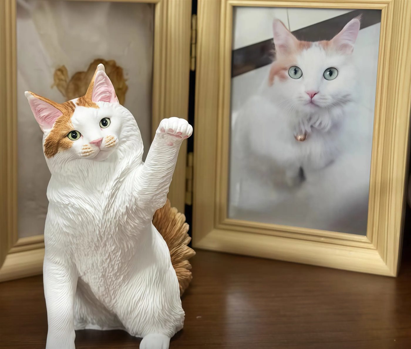 custom cat figurine displayed beside a framed cat photo